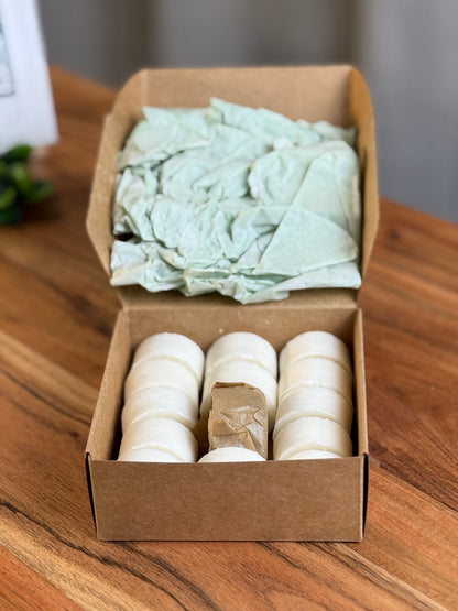 Geöffnete Soulyful Box mit 13 Rapswachs-Teelichtern und einem verpackten Glasteelichthalter