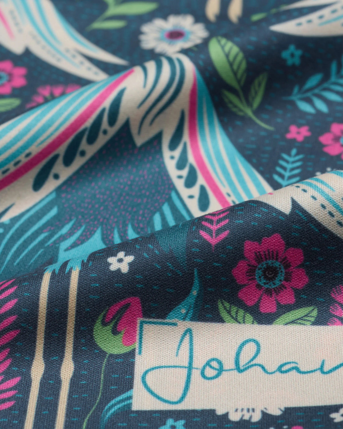 Nahaufnahme des Kranichmotivs und Markenlogos auf dem Johans® Mikrofasertuch Midnight Crane