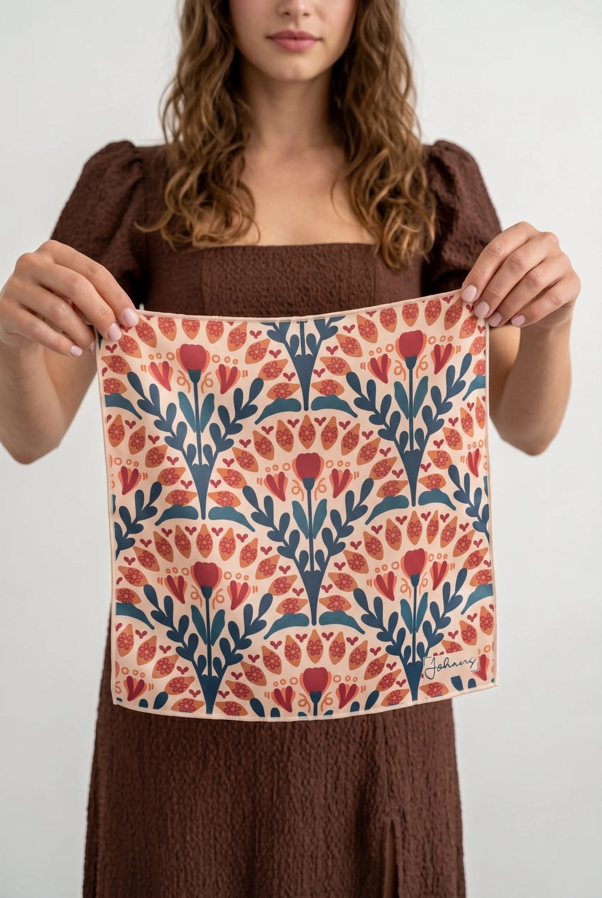 Ausgebreitetes Johans® Mikrofasertuch Vintage Bloom mit symmetrischem Blumenmuster in den Händen einer Person