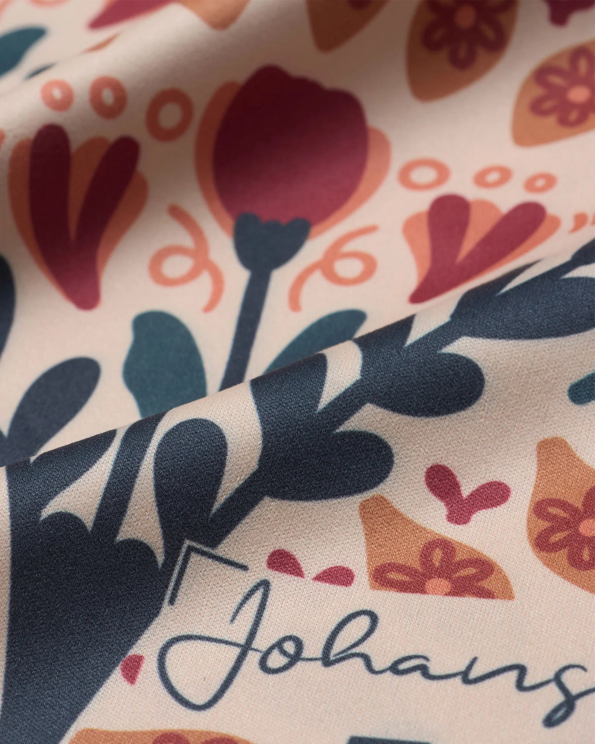 Nahaufnahme des Johans® Mikrofasertuchs Vintage Bloom mit Blütenmuster und Markenlogo