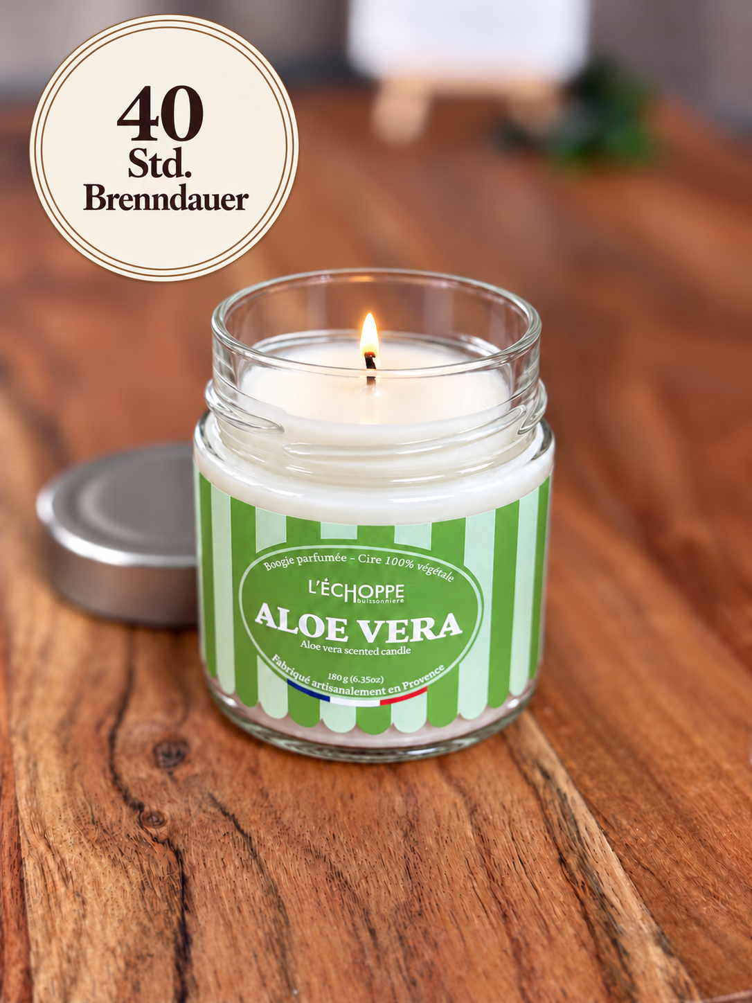 Duftkerze "Aloe Vera" auf Holztisch mit kleiner Flamme und Siegel „40 Std. Brenndauer“