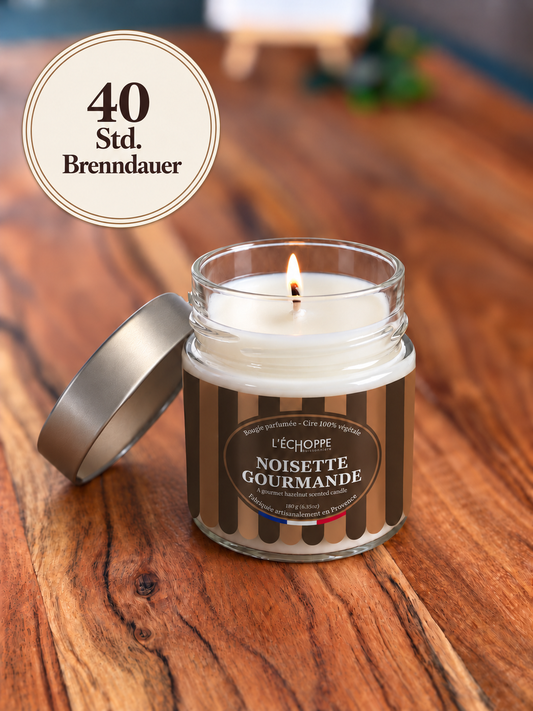 Duftkerze "Gourmet-Haselnuss" Winter-Edition auf Holztisch mit kleiner Flamme und Siegel „40 Std. Brenndauer“