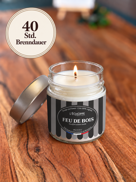 Duftkerze "Holzfeuer" auf Holztisch mit kleiner Flamme und Siegel „40 Std. Brenndauer“