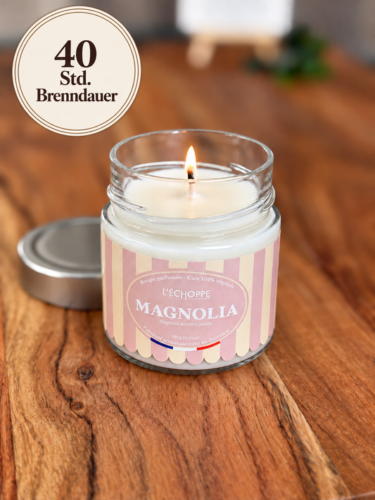 Duftkerze "Magnolie" auf Holztisch mit kleiner Flamme und Siegel „40 Std. Brenndauer“