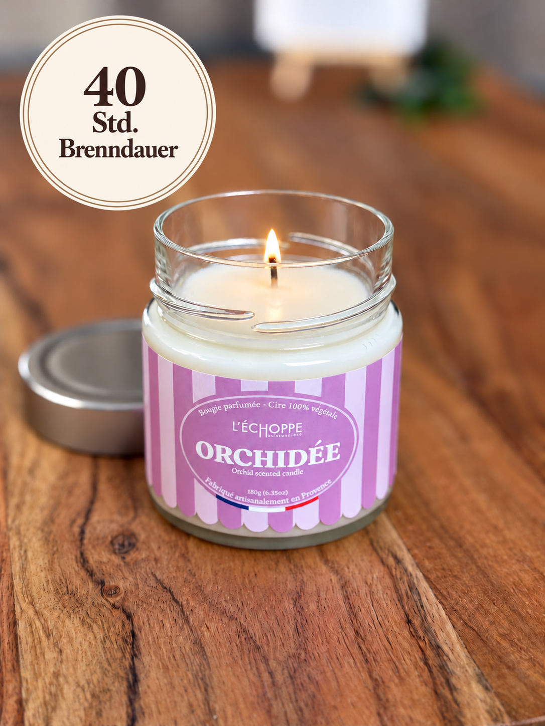 Duftkerze "Orchidée" auf Holztisch mit kleiner Flamme und Siegel „40 Std. Brenndauer“
